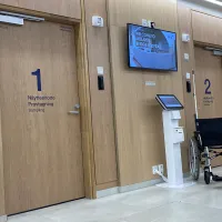 Sairaalan päivystys. Aulassa pyörätuoli ja kaksi ovea näytteenottoon.
